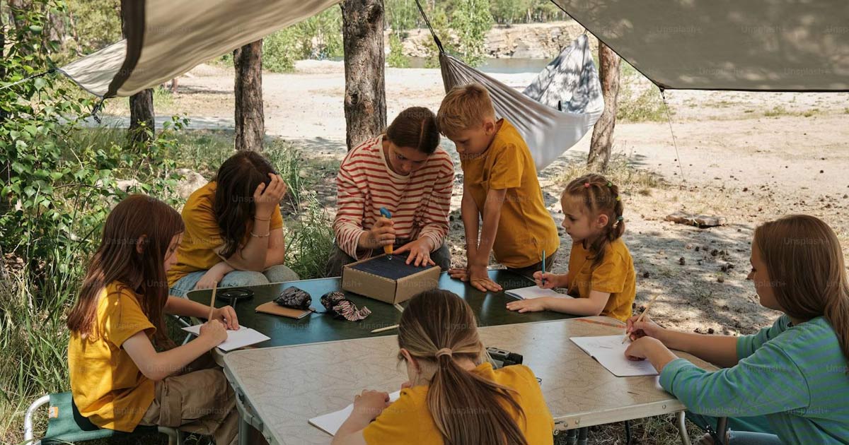 Counselor with campers doing arts and crafts
