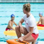 Lifeguard supervising children during a summer camp swim period